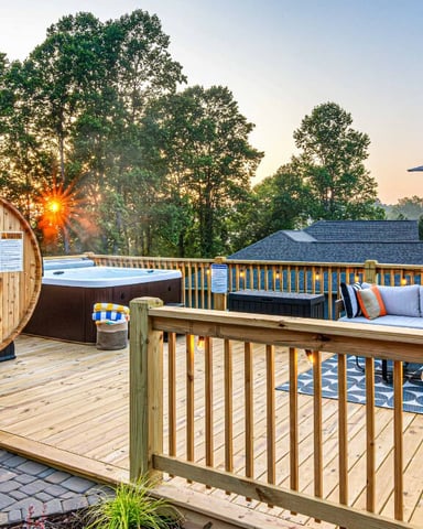 Hot tub on a deck at night with mountain views and full moon